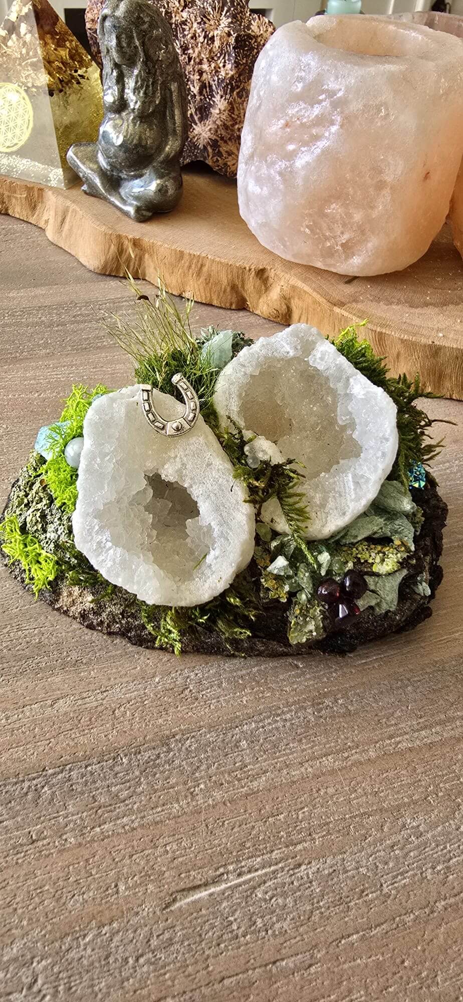 Twee witte geodes met hoefijzer-amulet op moss